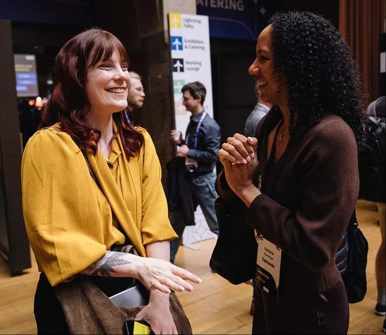 Two attendees laughing together between sessions