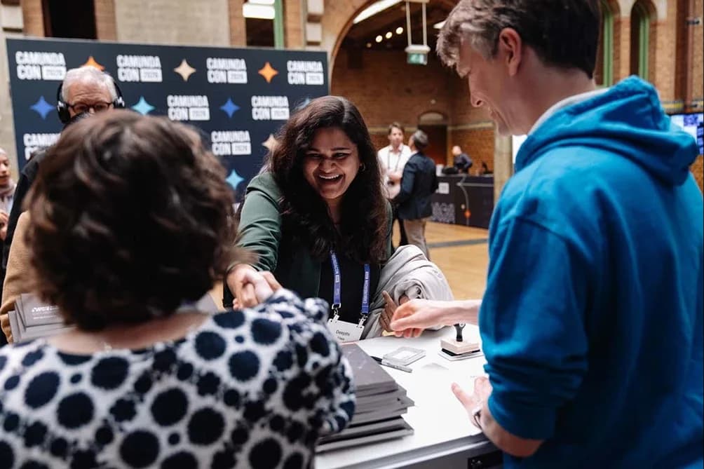 An attendee being welcomed at the registration desk